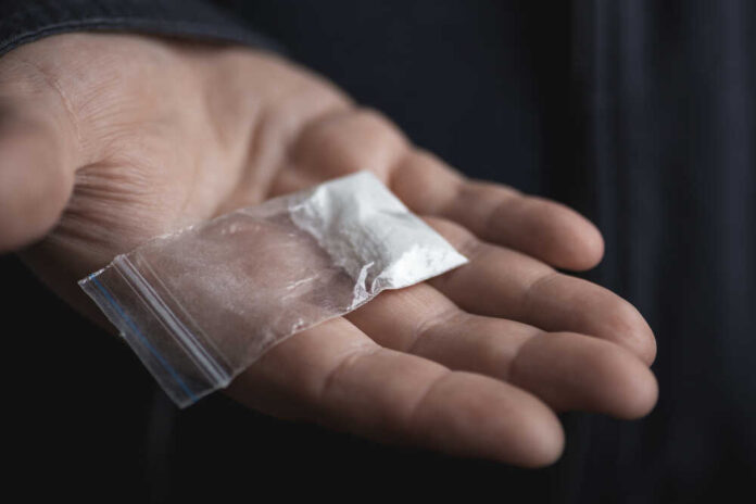 Mans,Hand,Holding,On,Palm,Plastic,Packet,With,Cocaine,Powder