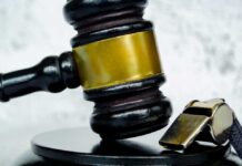 Gavel and whistle on gray background close up