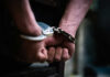 Close-up of hands in handcuffs behind back.