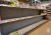 Empty supermarket shelves with sparse products displayed