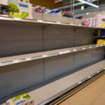 Empty supermarket shelves with sparse products displayed