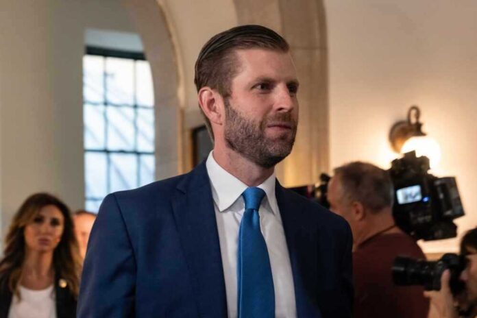 shutterstock_2369816051.jpg featured image Eric Trump in suit and blue tie surrounded by people.