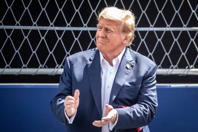 shutterstock_2459917047.jpg featured image Donald Trump clapping, wearing suit.
