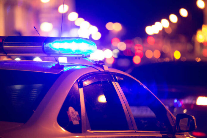 shutterstock_448997113.jpg featured image Police car with blue lights flashing at night.