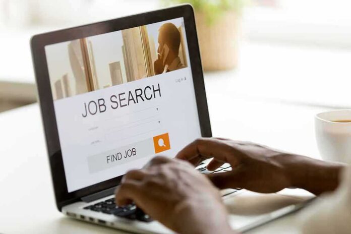1044298738 featured image Person searching for jobs on a laptop.