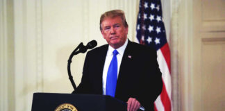 Donald Trump speaking at podium.