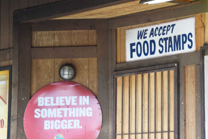Wooden wall with food stamps and believe signs