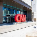 CNN headquarters entrance with large red logo outside.