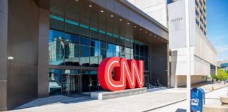 CNN headquarters entrance with large red logo outside.