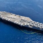 Aircraft carrier with planes in the ocean
