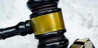 Gavel and whistle on gray background close up