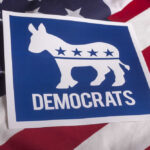 Democratic Party donkey logo on American flag background.