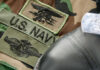 Military patches and dog tag on camouflage fabric