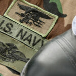 Military patches and dog tag on camouflage fabric