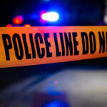 Mass Shooting at Class Reunion Police tape with flashing lights in the background