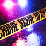 American Idol Exec Gunned Down In Cold Blood Crime scene tape with flashing lights in background.