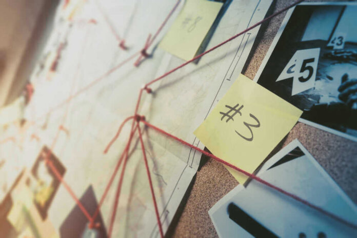 shutterstock_1192132657.jpg Investigation board with photos notes and red string