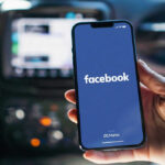 Phone displaying Facebook app in a car