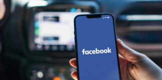 Phone displaying Facebook app in a car