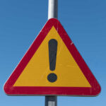 Triangular warning sign with exclamation mark.