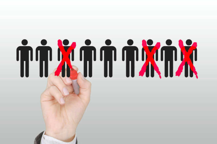 Hand crossing out stick figures with a red marker