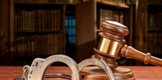 Wooden gavel and handcuffs on a table