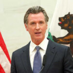 Illegal Alien’s TRUCK CRASH; 3 Innocent Lives LOST; Gavin Newsom to BLAME?! Gavin Newsom speaking at podium.