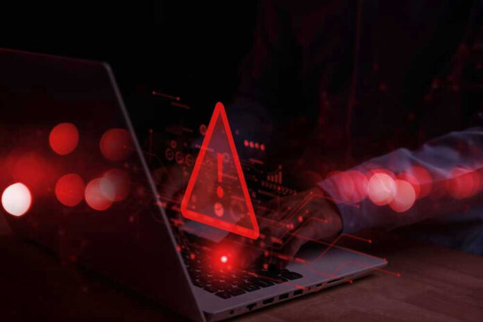 Warning symbol over laptop with user