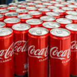 Coca-Cola cans stacked on a surface.