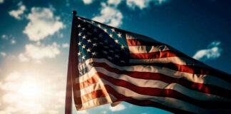 American flag waving against a bright sky