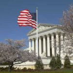 US Supreme Court building with an American flag