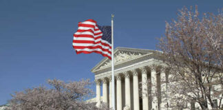 US Supreme Court building with an American flag