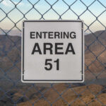 Sign indicating entry to Area 51 with a mountainous background