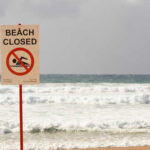 Labor Day NIGHTMARE: Beaches Closed! (Video) Sign indicating the beach is closed with a no swimming symbol