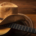 Country Music Star Suffers Heart-Wrenching Loss Cowboy hat on guitar next to coiled rope