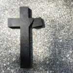 Church Monster EXPOSED After 60 Years Broken black cross on a gray surface.