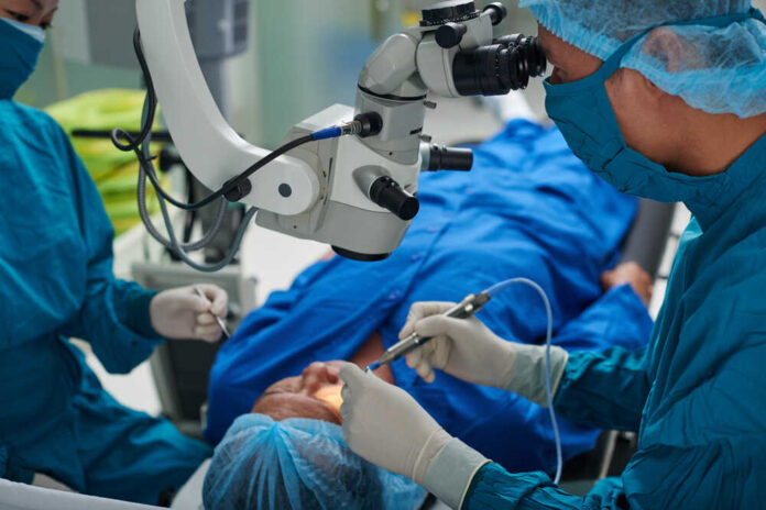 Surgeons performing eye surgery with a microscope