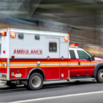Jesse Jackson Hospitalized: Rare Brain Disorder Red and white ambulance driving on a city street.