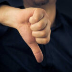 Popular Restaurant’s SHOCKING Collapse — CEO Admits Fatal Mistake Hand showing thumbs down gesture, dark background.