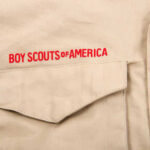 Pentagon Drops Bombshell on Scouting America Close-up of a khaki shirt with 'Boy Scouts of America' embroidered on it