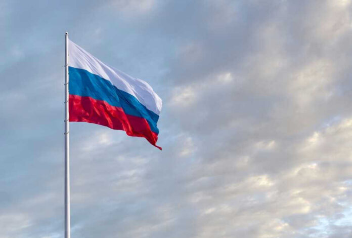 Russian flag waving against a cloudy sky.