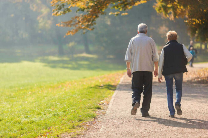 Two people walking together on a park path.