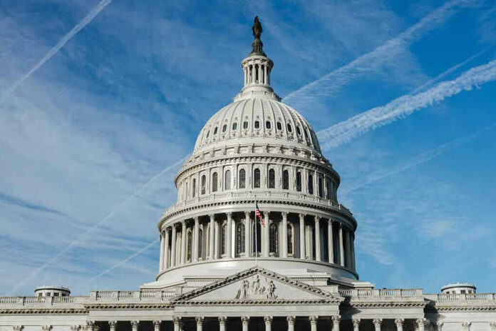 U.S. Capitol building dome against blue sky.