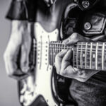 Close-up of a musician's hands playing an electric guitar