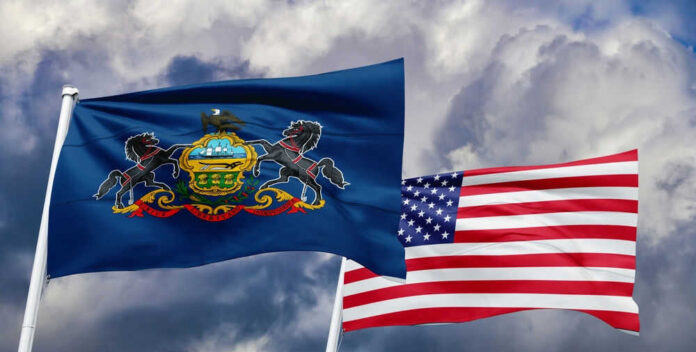 Pennsylvania and United States flags waving in clouds.