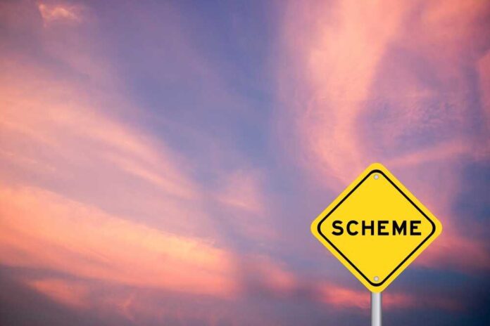 A yellow warning sign with the word 'SCHEME' against a colorful sky