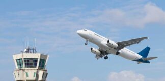 An airplane taking off near an airport control tower