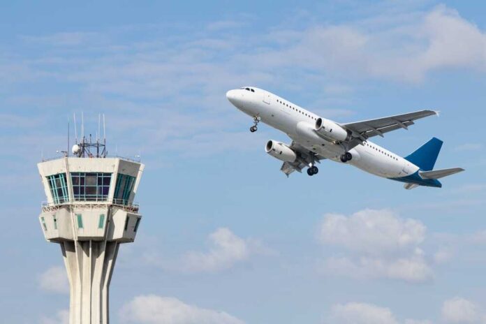 An airplane taking off near an airport control tower