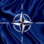 NATO Blinks First in High-Stakes Arctic Standoff NATO flag with white compass emblem on blue background.