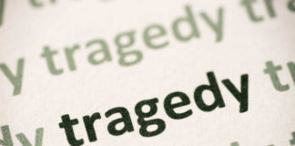 Close-up of the word 'tragedy' printed multiple times in varying shades